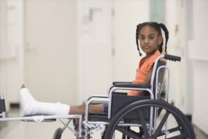 child in wheelchair with broken leg