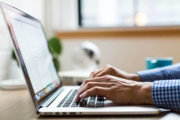 Freelance lawyer working on a Macbook, highlighting the remote work possibilities in freelance law.