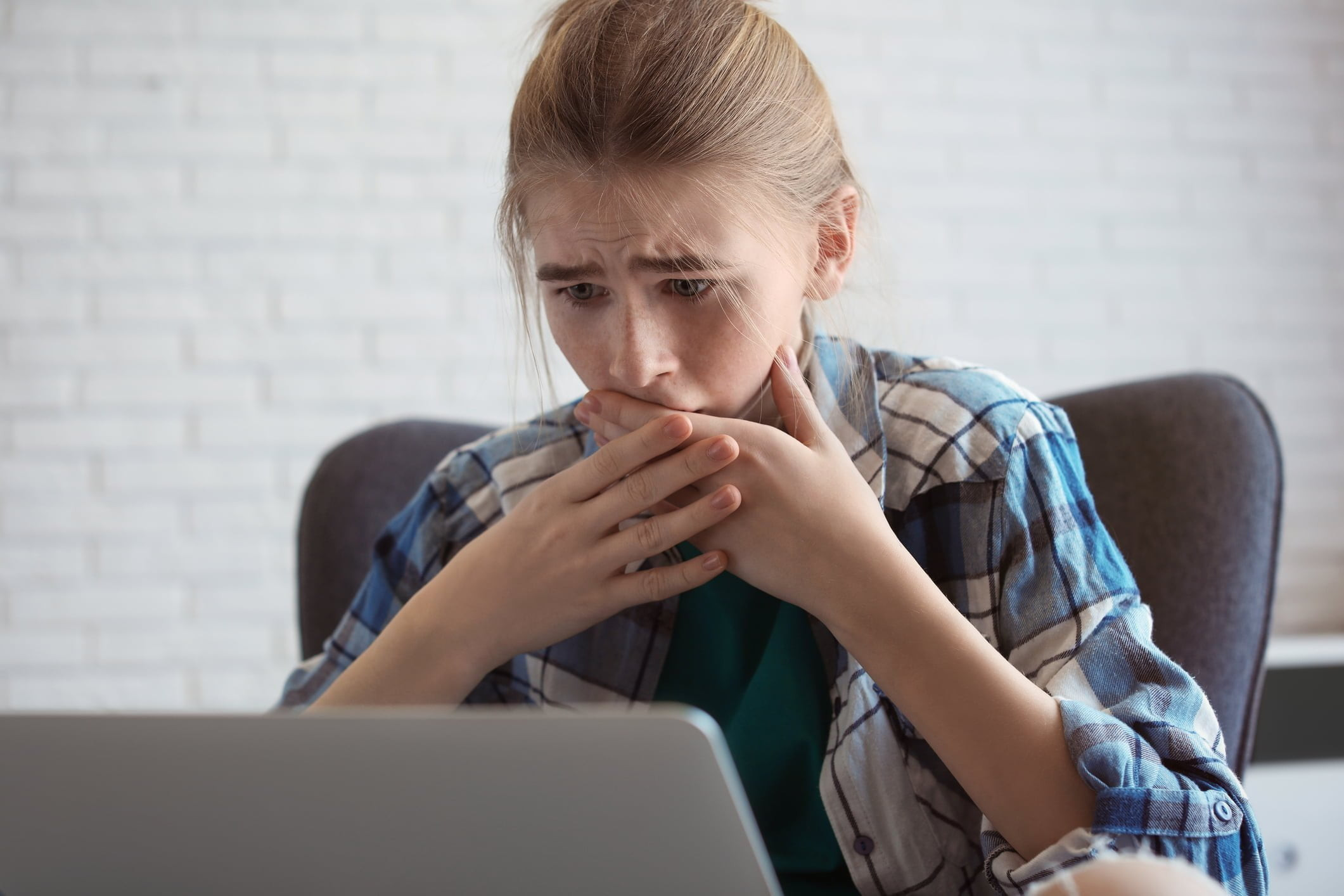 Teenage girl shocked by online content, highlighting the dangers of the internet and doxing