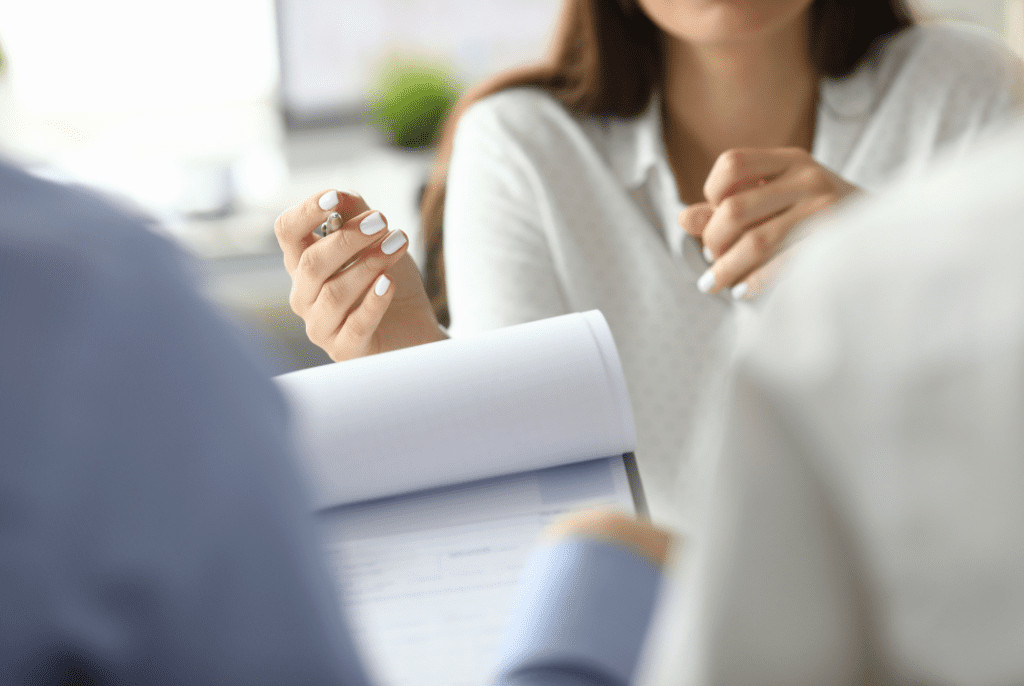 A woman discussing a document with two people