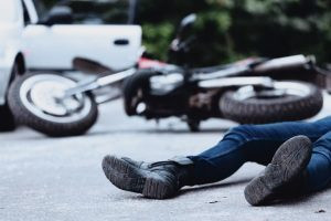 Motorcycle accident victim lying unconscious on the street, emphasizing the need for immediate legal help from the best lawyer for motorcycle accidents