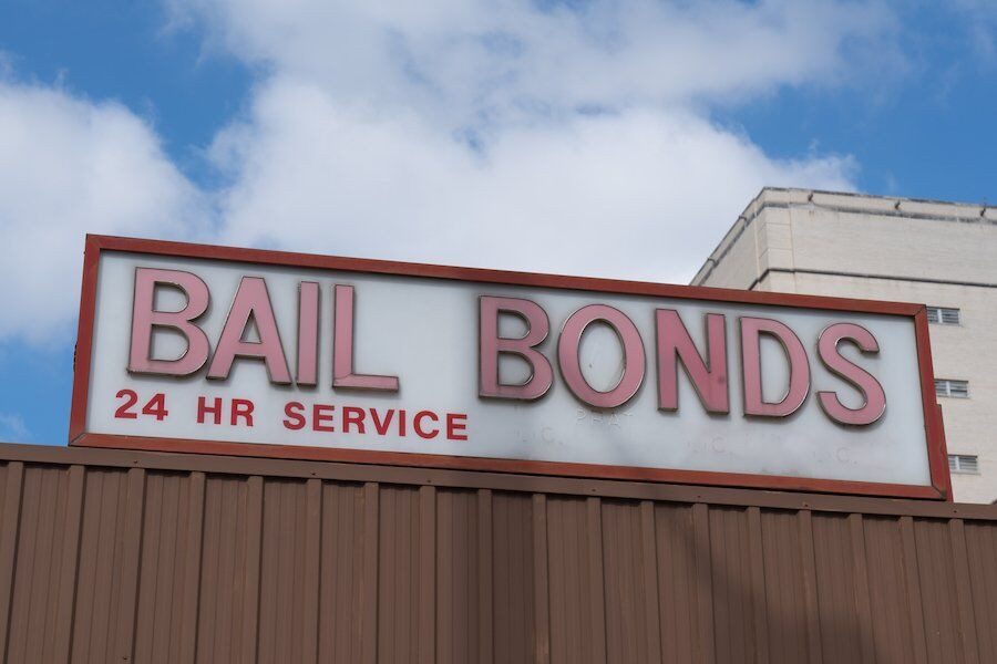 Exterior view of a bail bonds company storefront under a clear blue sky.