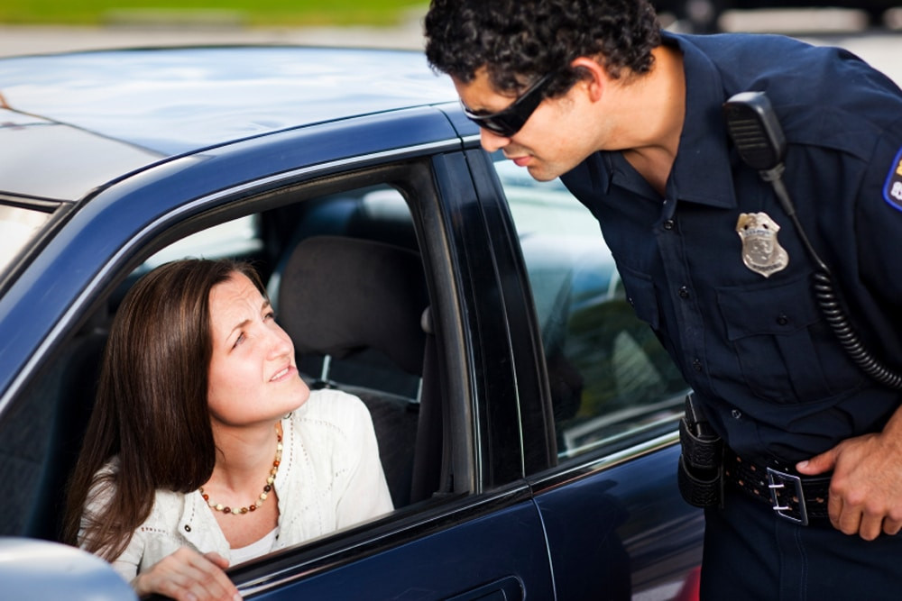 A police officer pulling over a car for a speeding ticket, highlighting the need for a traffic ticket dismissal lawyer in El Paso.