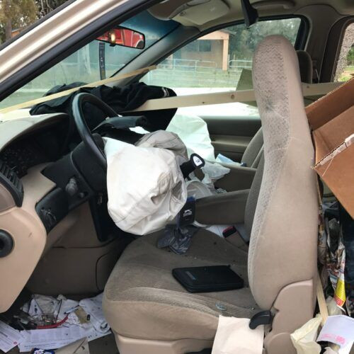 Inside of a car involved in an accident showing deployed airbags and pushed forward seat, representing car accident damage in Clearwater.