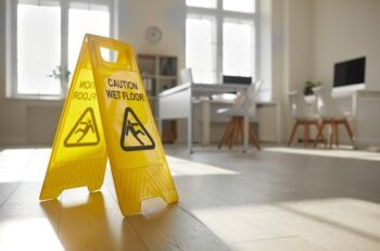 A yellow slip-and-fall sign on a wet floor, symbolizing premises liability. Alt text: A Jacksonville personal injury lawyer can help you navigate slip and fall accidents and seek compensation for injuries sustained on unsafe premises.