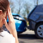 A stressed driver contemplating contacting a car wreck lawyer in Louisville after an accident.