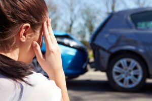 A stressed driver contemplating contacting a car wreck lawyer in Louisville after an accident.