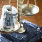Scales of justice balanced with stacks of hundred-dollar bills, symbolizing the high corporate lawyer salary in New York City, especially for entry-level positions at prestigious law firms.