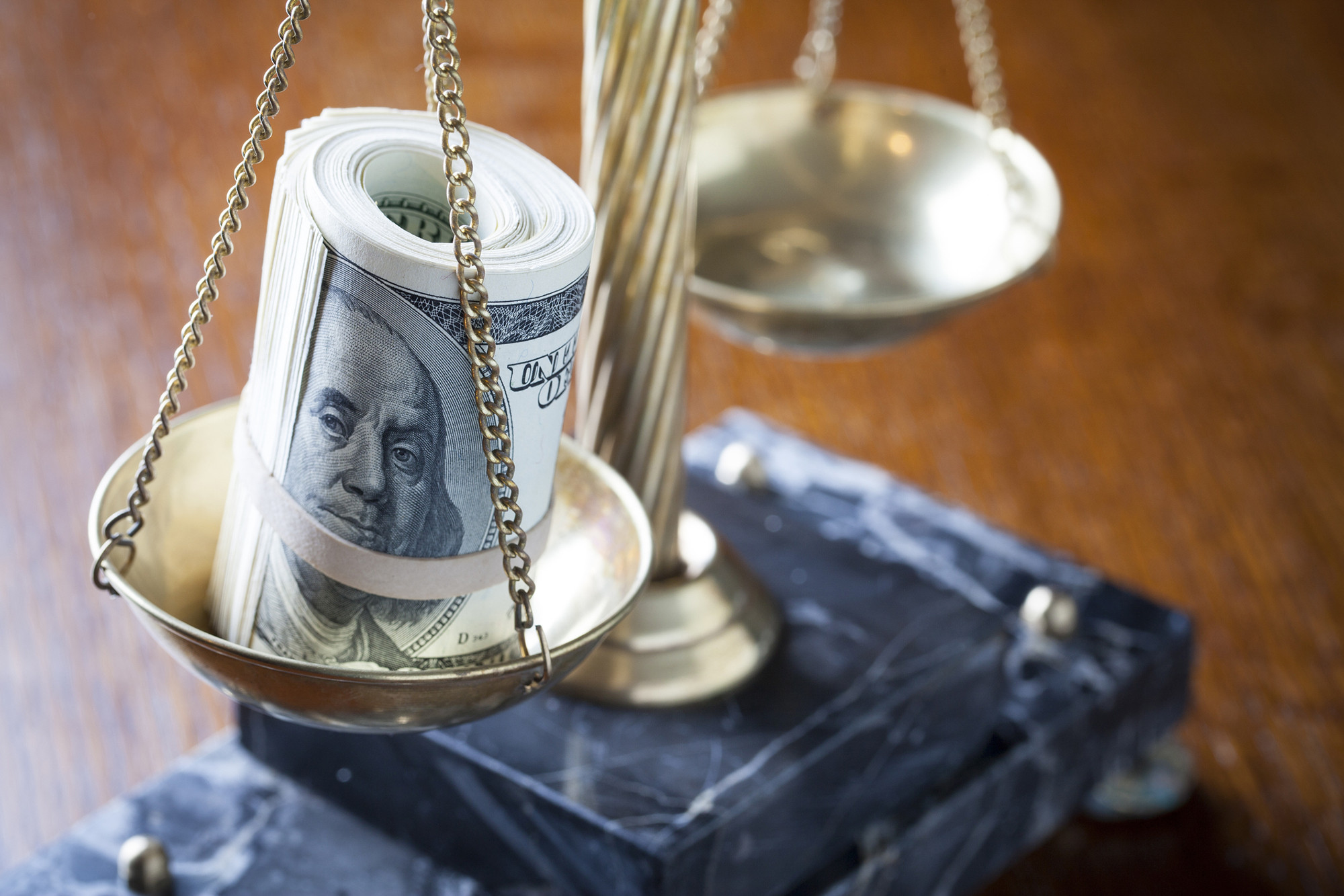 Scales of justice balanced with stacks of hundred-dollar bills, symbolizing the high corporate lawyer salary in New York City, especially for entry-level positions at prestigious law firms.