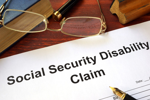 Person reviewing a document with a magnifying glass, possibly related to SSDI application review