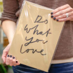 A person holding a sign that says do what you love.