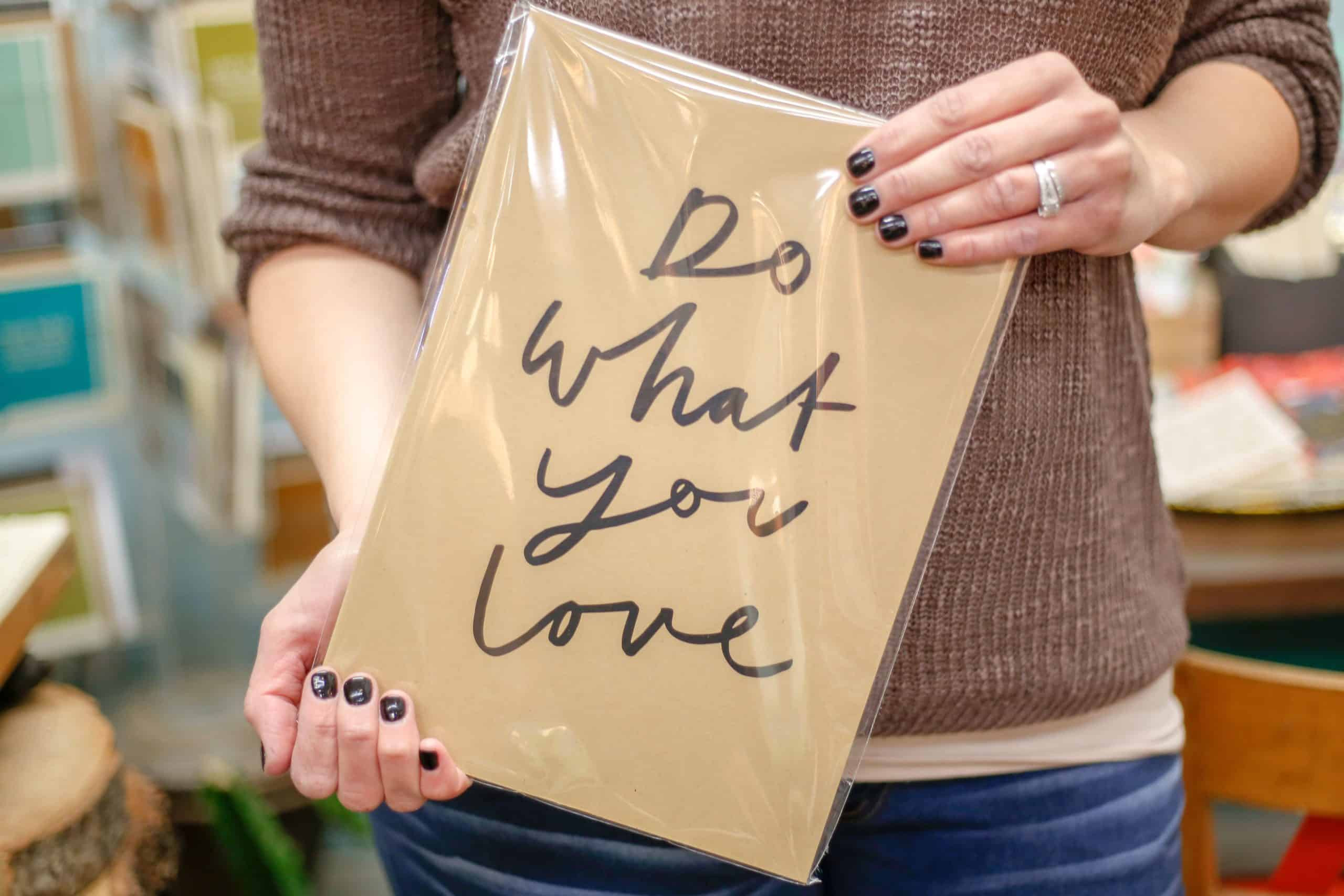 A person holding a sign that says do what you love.